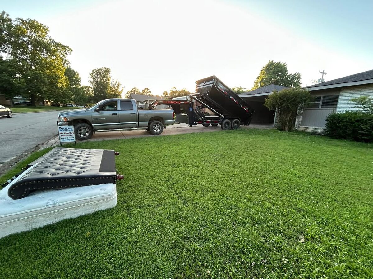 A&K truck and dump trailer hauling away debris from a property cleanout