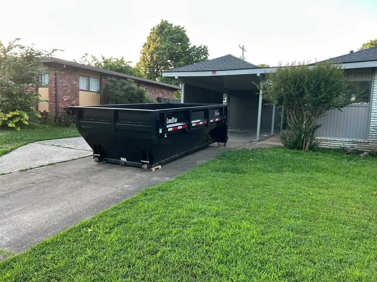 Roll-off dumpster placed neatly on a residential driveway at golden hour